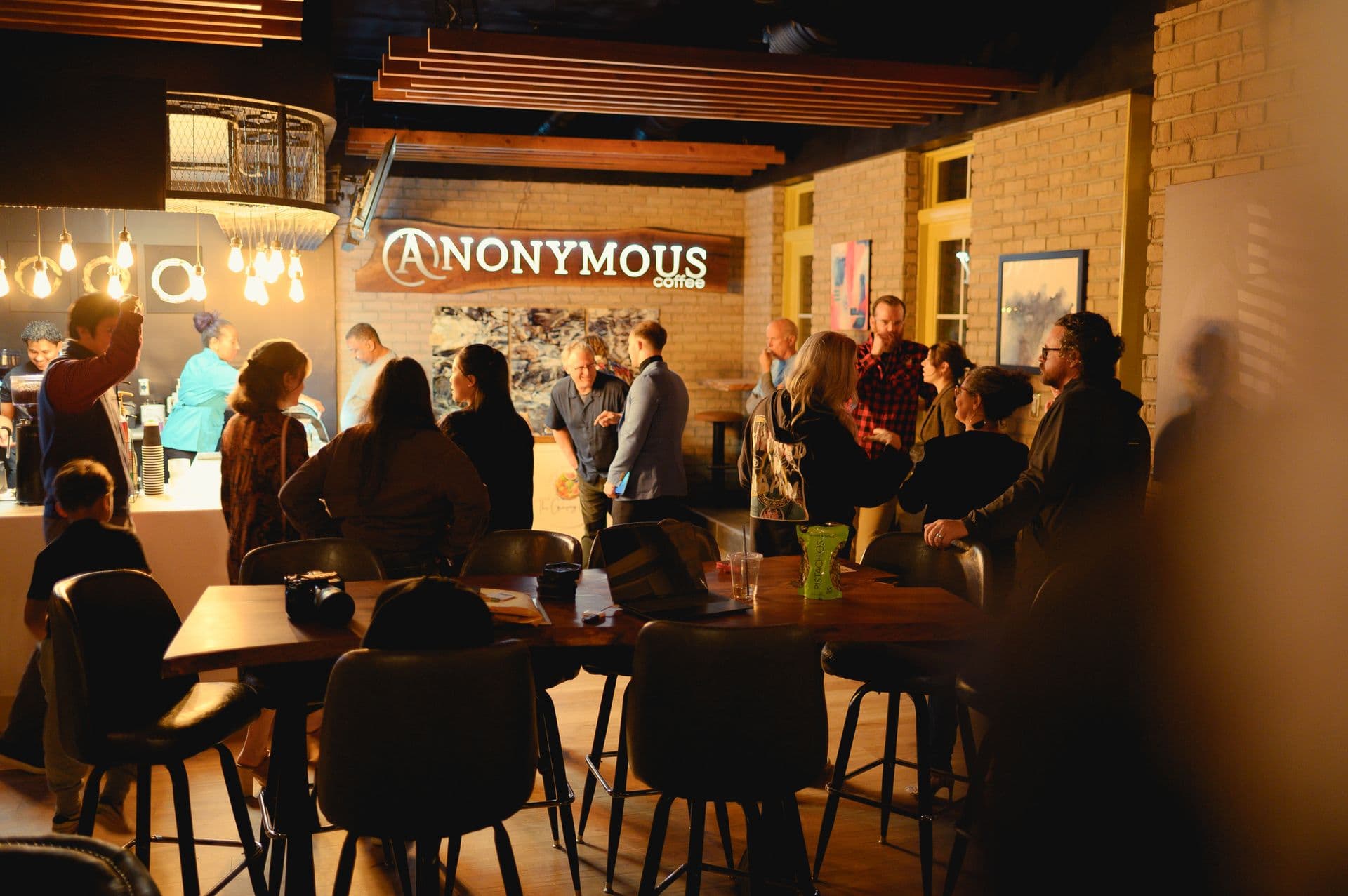 Anonymous Coffee interior with guests gathered around the bar